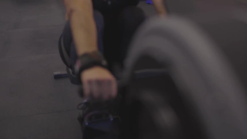 A white woman in workout clothing exercises on a gym machine