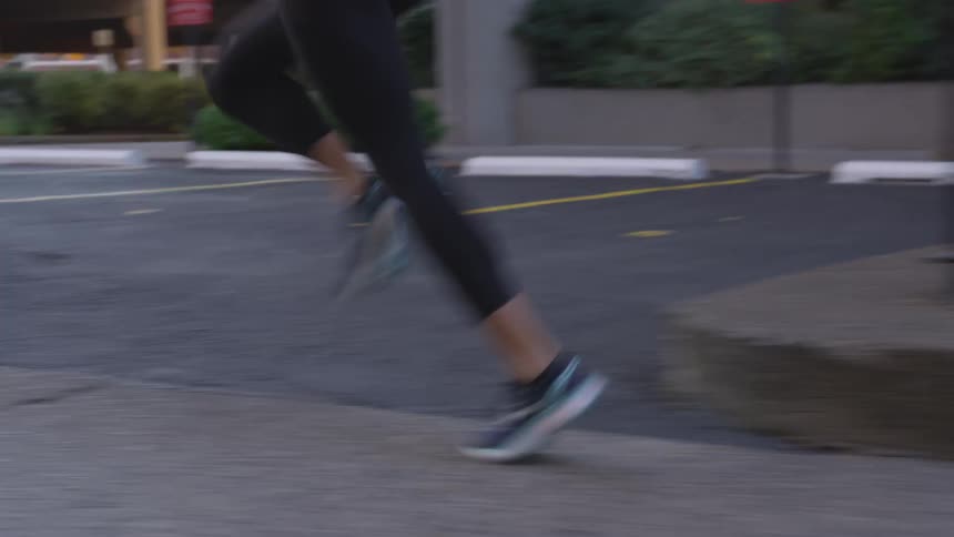 A white woman jogs down a sidewalk