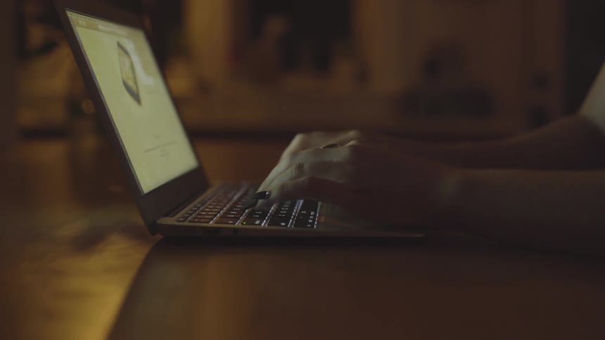 A woman typing on a laptop