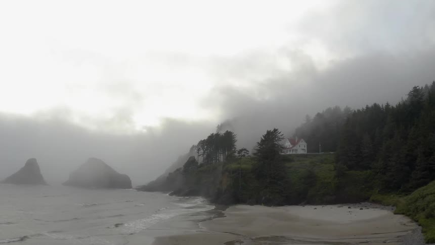 A house on a hill near the fog covered beach