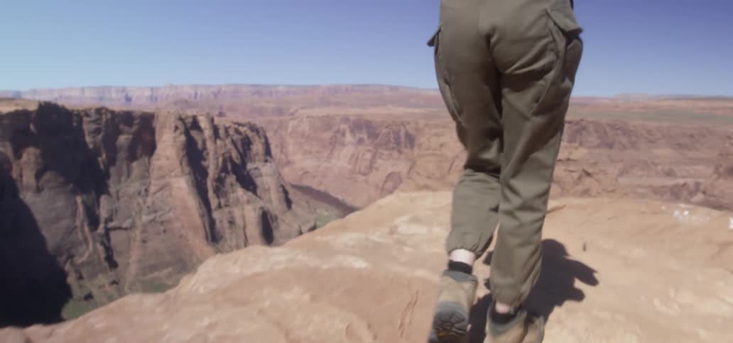 Photographer hiking over a rock in the canyon to take a picture