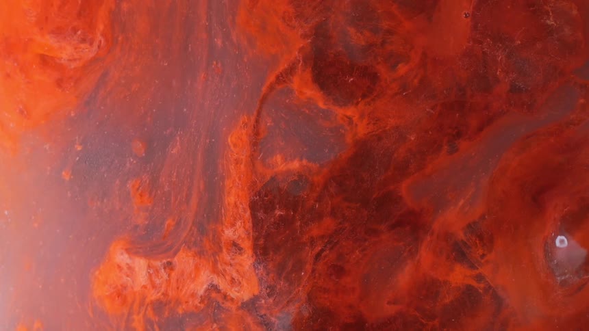 Water with orange clouds floating around inside