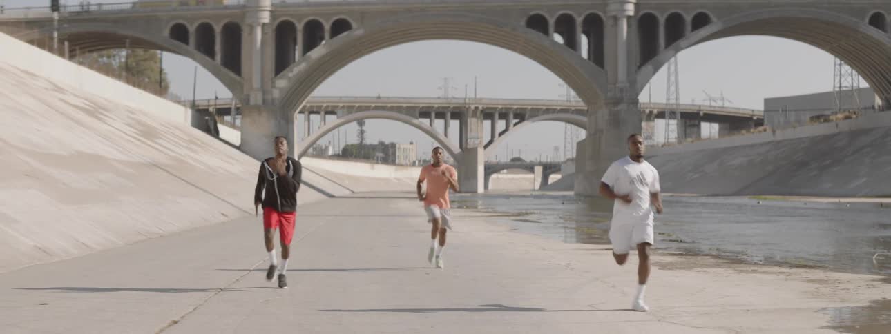 Three men running down a path