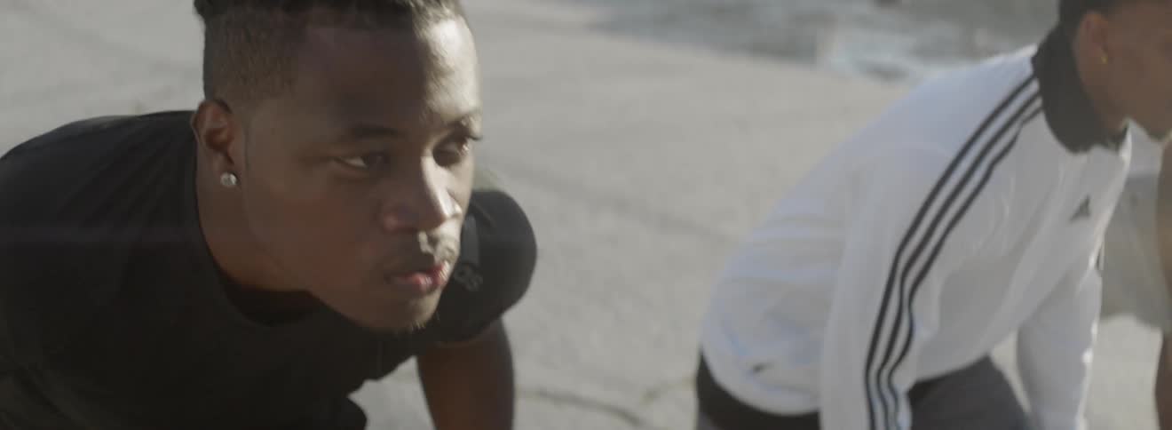 Young black men prepare for race on beach and start running