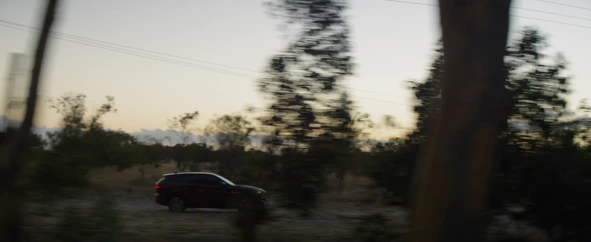 Black suv drives down dirt trail at dusk