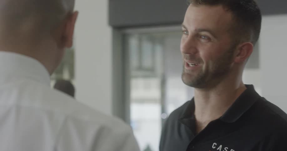 A man talks with another man inside a building