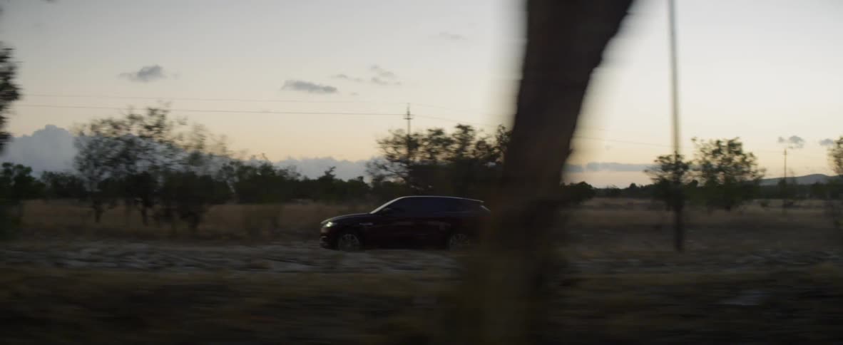 A car drives down a rural road