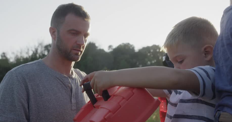 Boy opening a tackle box with dad