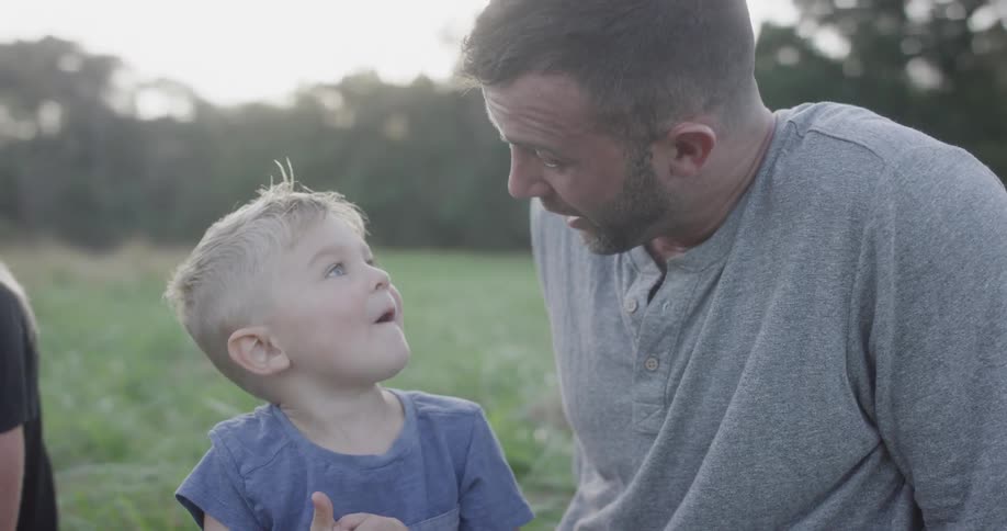 A man and his son sitting in a field