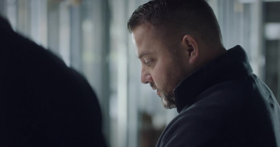 Two men inside standing and talking
