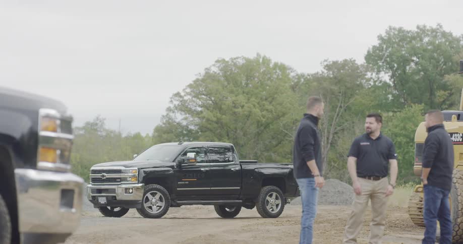 3 men talking by trucks