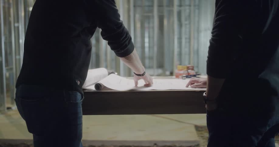 Men checking a blueprint on a construction site