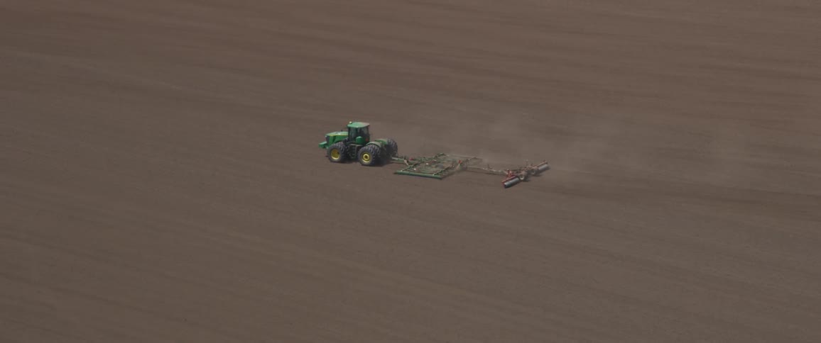 A tractor plows a field