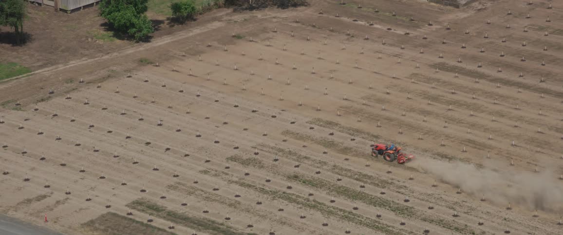 Tractor pulls an implement through the field on the farm