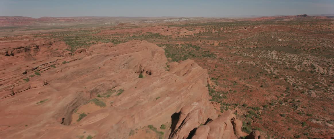 The camera flies over a sandstone desert landscape