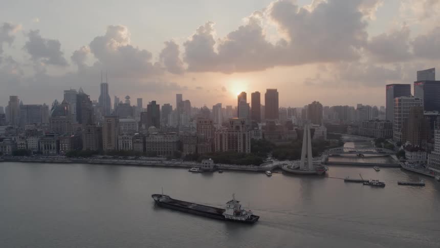A barge sails through the Bund river in front of the Shanghai skyline