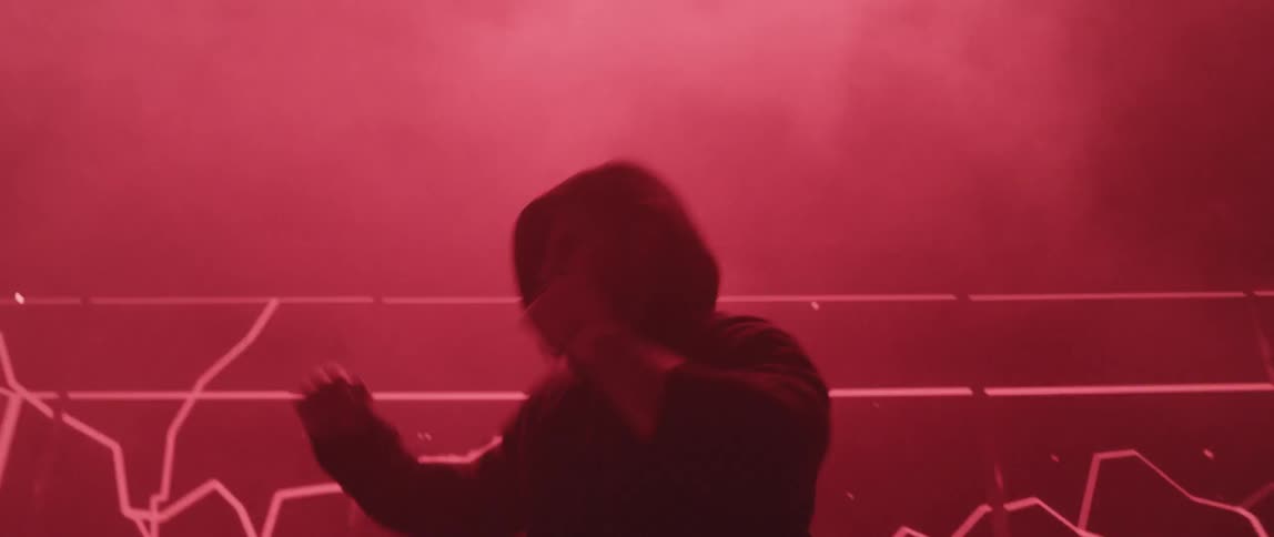 A man shadow boxing surrounded by strobe lights