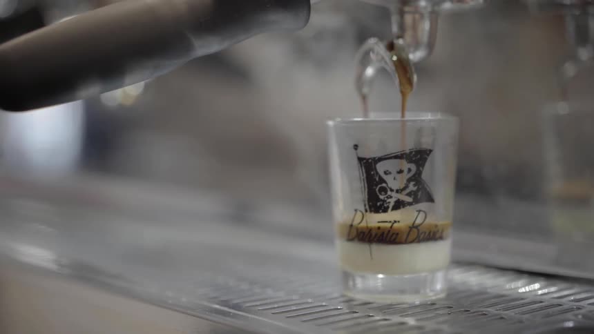 A glass filling with hot coffee