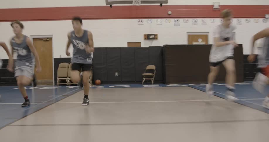 Boys running drills in an indoor gym