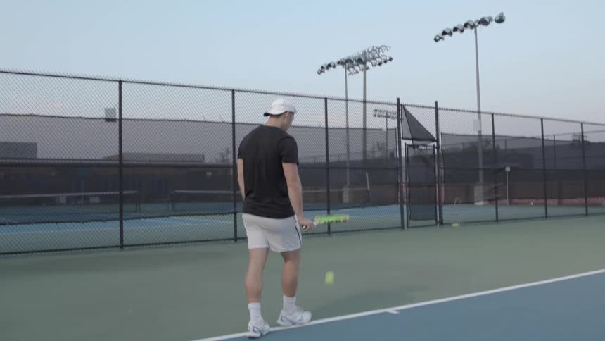 A man bouncing a tennis ball with a racquet