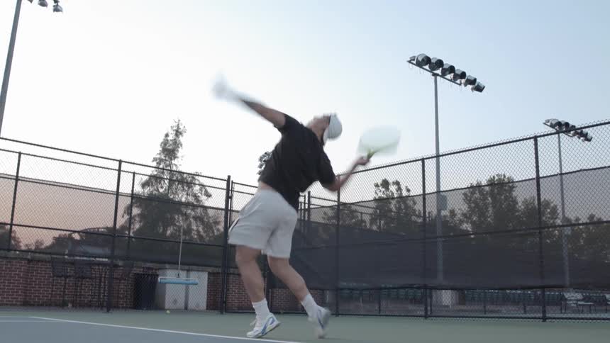 Man serving a tennis ball at a tennis court