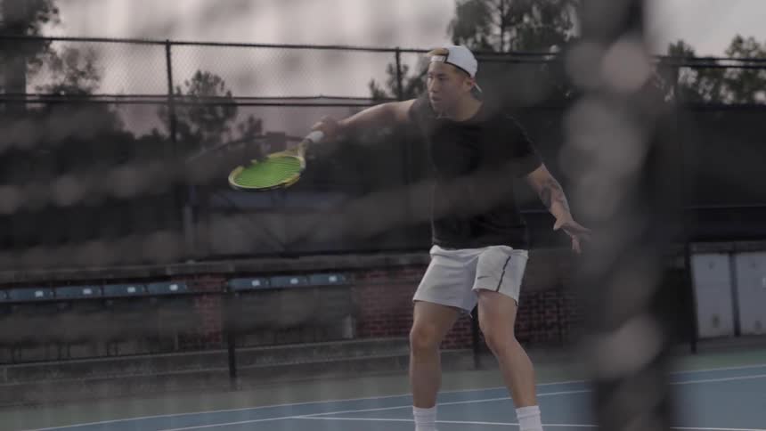 A man playing tennis outside