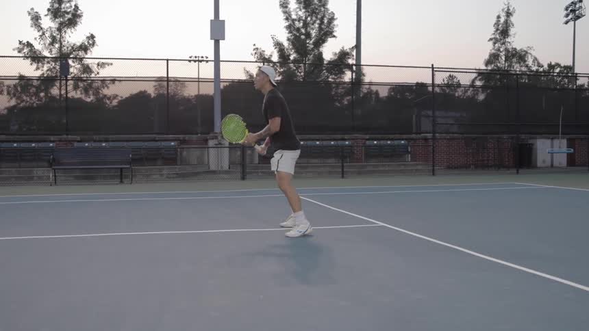 White man playing tennis in a tennis court