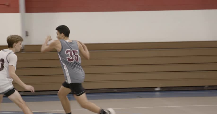 Teenagers playing basketball in a gymnasium