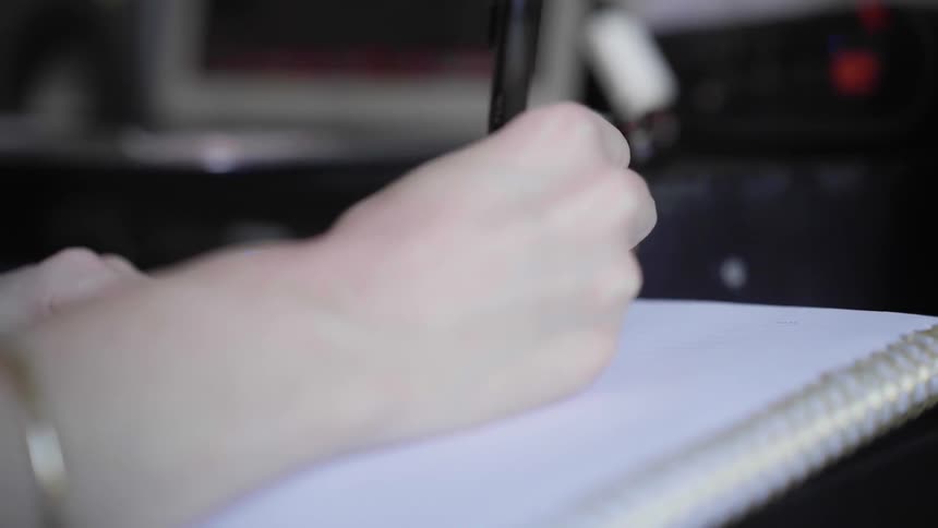 A person writes in a notebook