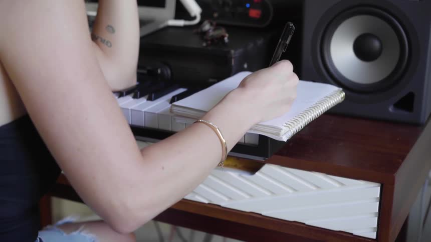 Girl Writes Lyrics in a notebook