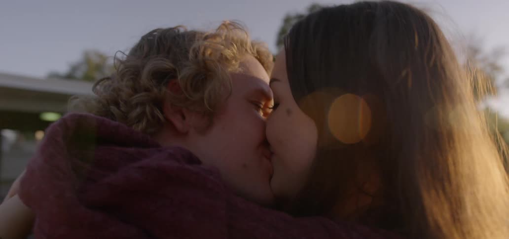A couple kisses happily
