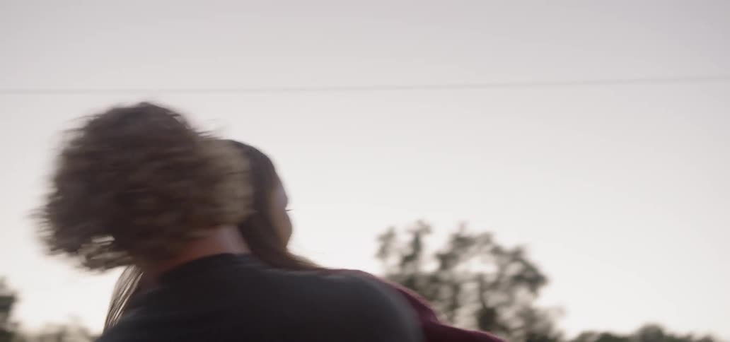 Man and woman hugging and spinning playfully on the street of a small town