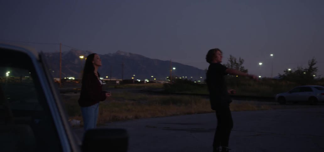Two young people throwing rocks at night