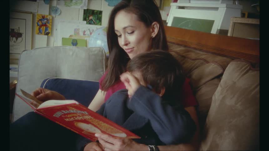 A mother reads a book to a child