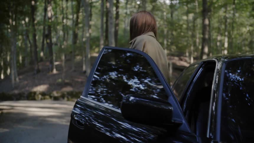 A woman gets out of the passenger side of a vehicle