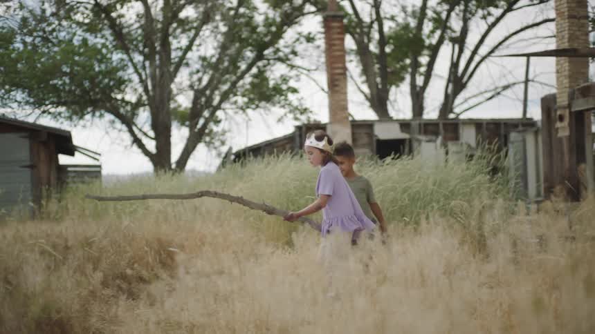 Two kids play with sticks