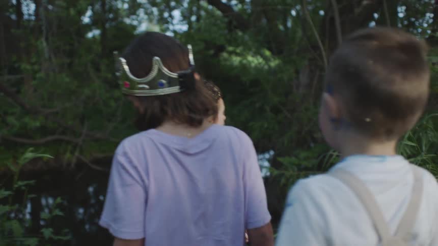 A group of kids walking towards a pond