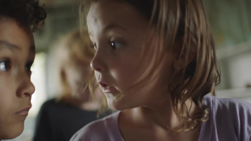 A girl turns her head and quickly looks at the boy beside her in surprise