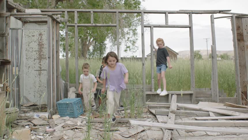 Four kids jump and play in a wooden structure
