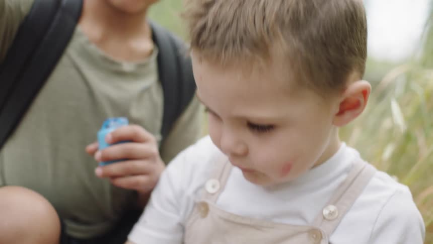 A boy taking an eyepatch off another boys head