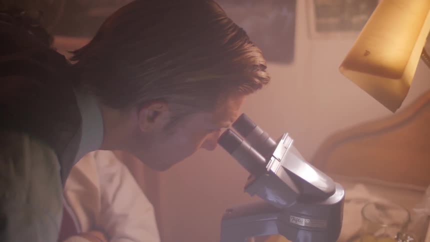 A man is looking through a microscope