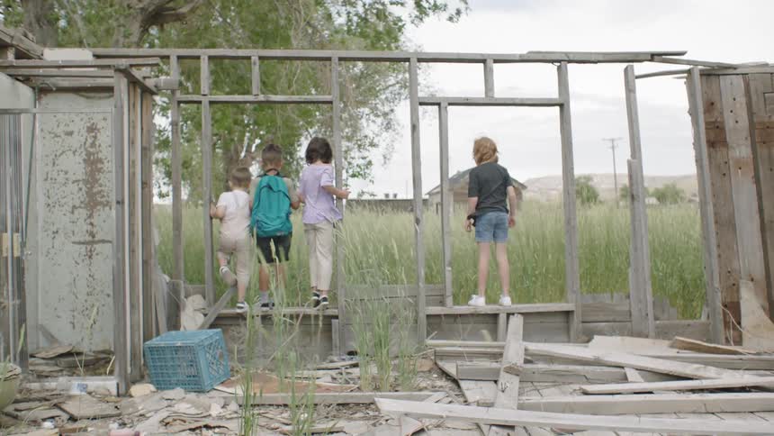 Four kids play on an abandoned building