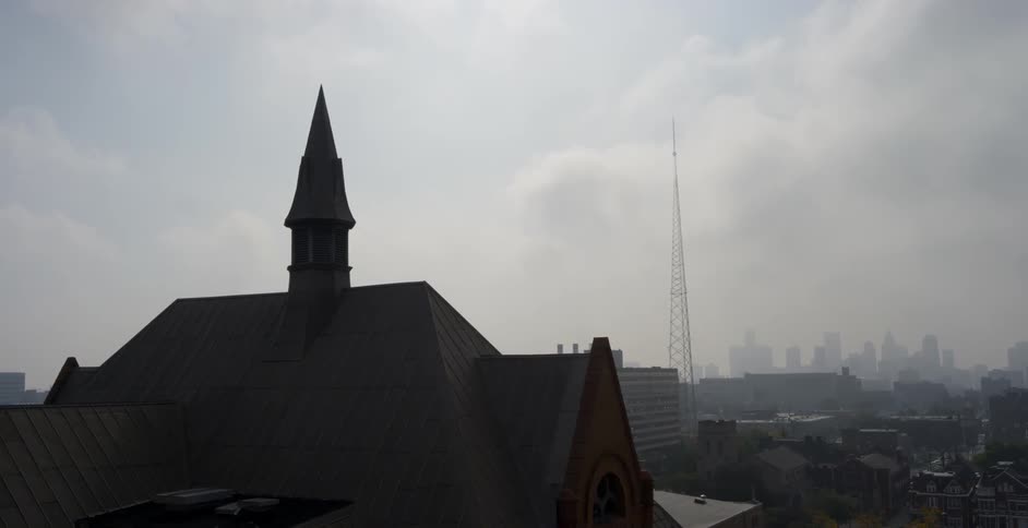 The steeple of a church before a city skyline