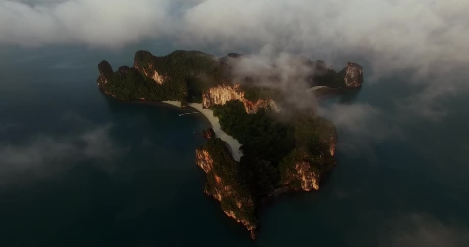 Clouds float over an island in the ocean