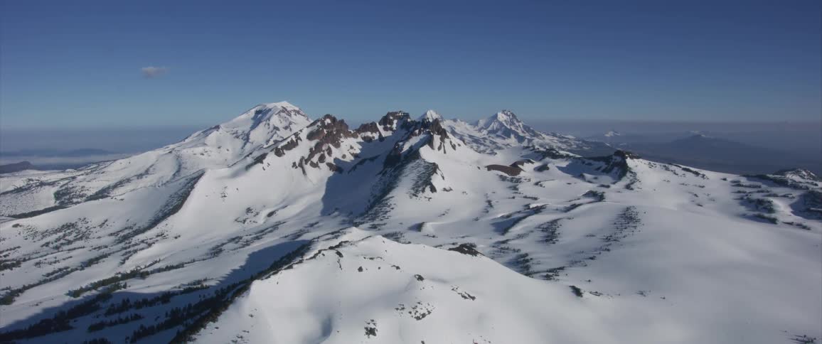 Aerial view of mountain range with peaks covered in snow