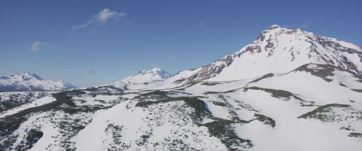 Clouds float over a snow covered mountain range