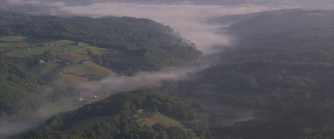 Clouds float above a rural and hilly landscape