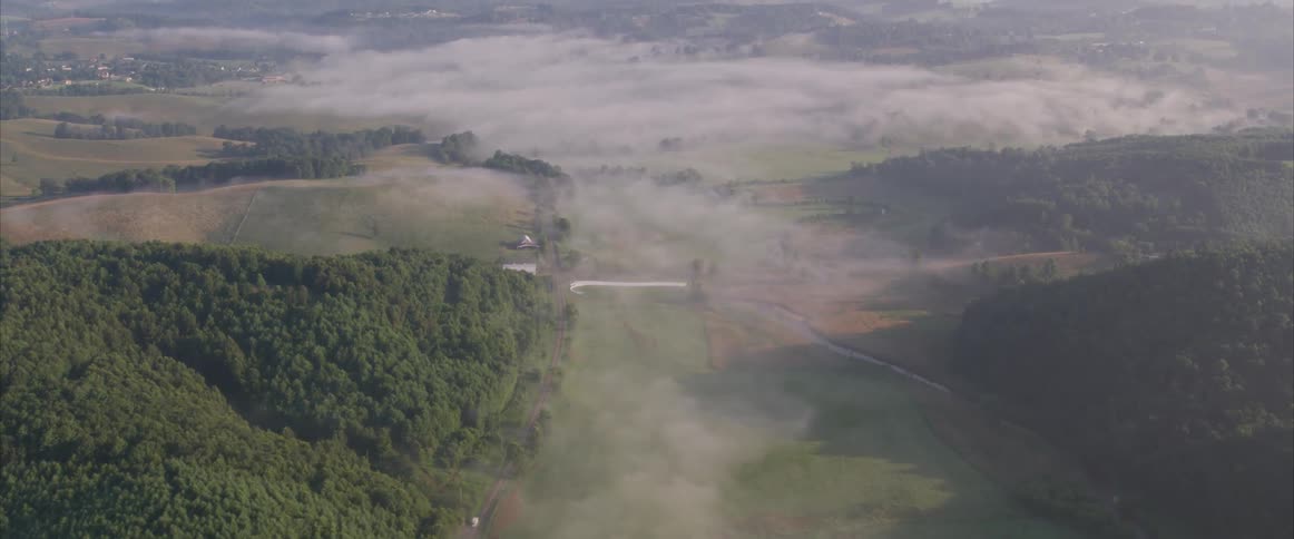 Clouds float above a rural and hilly landscape