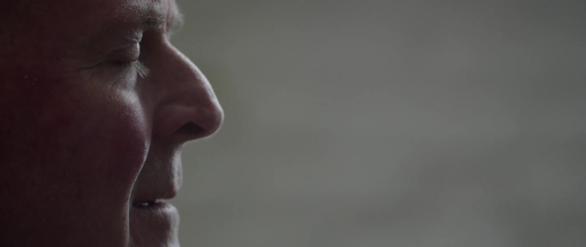 Close up profile view of elderly man blinking and smiling