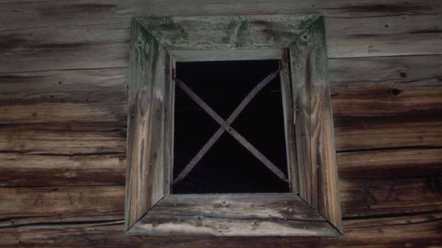 Window with wide wooden frame in wood walled building